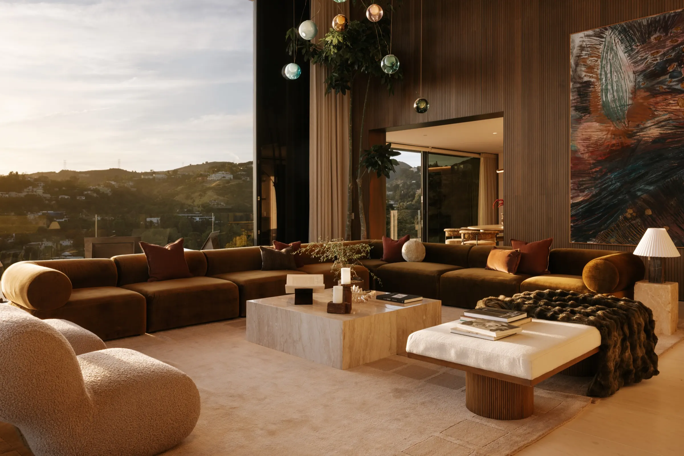 The Getty House, Brentwood — double-height great room at golden hour, walnut wall and pendant cluster