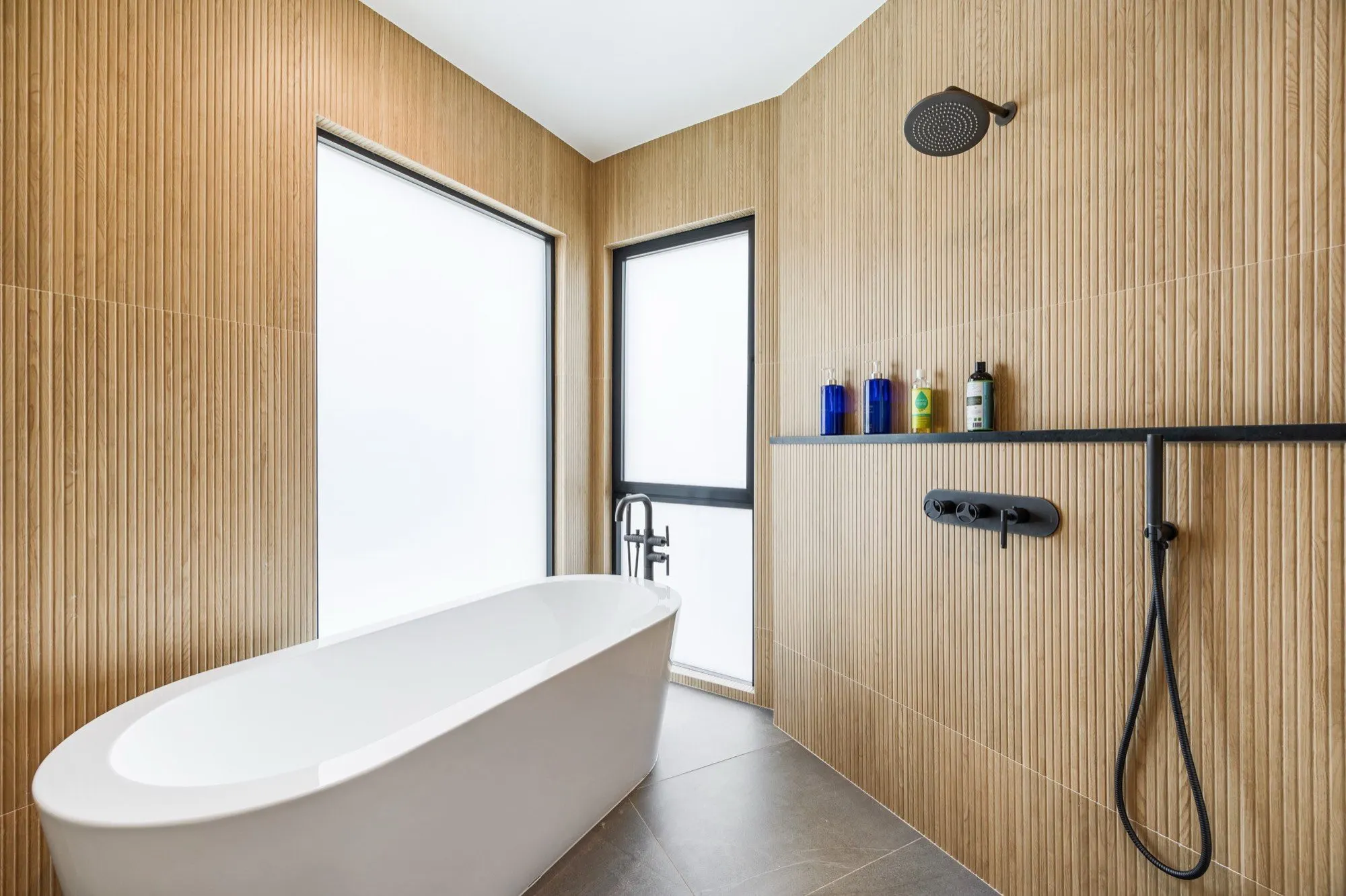 Islay Way — primary bath, freestanding tub wrapped in teak slat walls