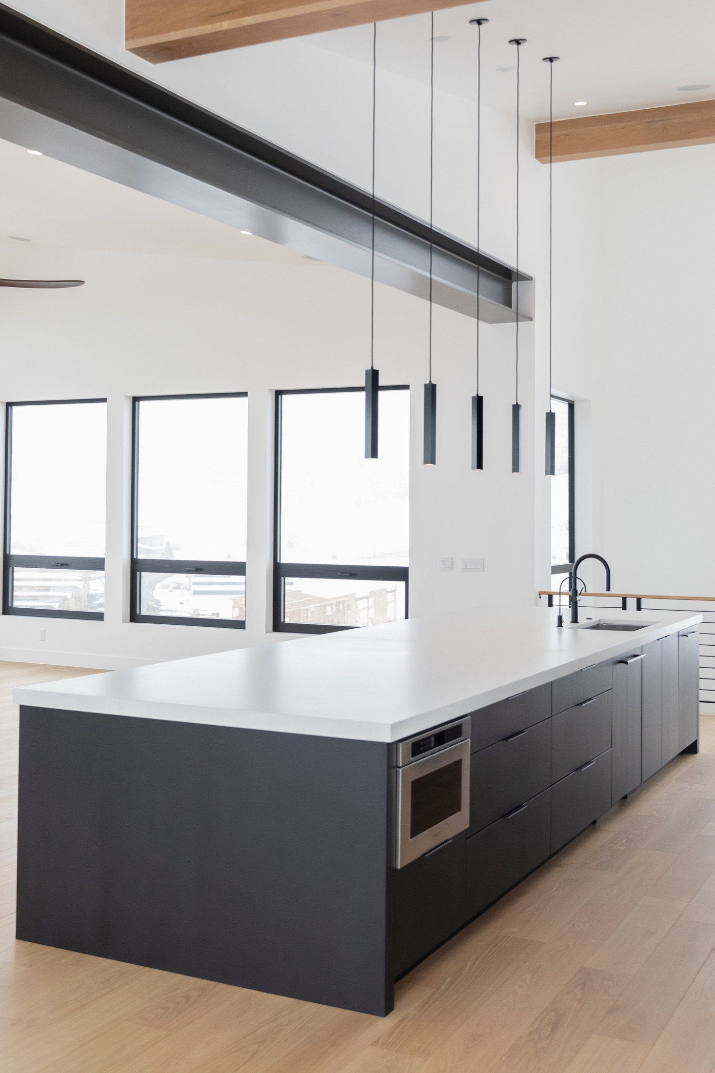 Benloch Ranch Lot 66 — kitchen island, black cabinetry, quartz countertop, linear pendants