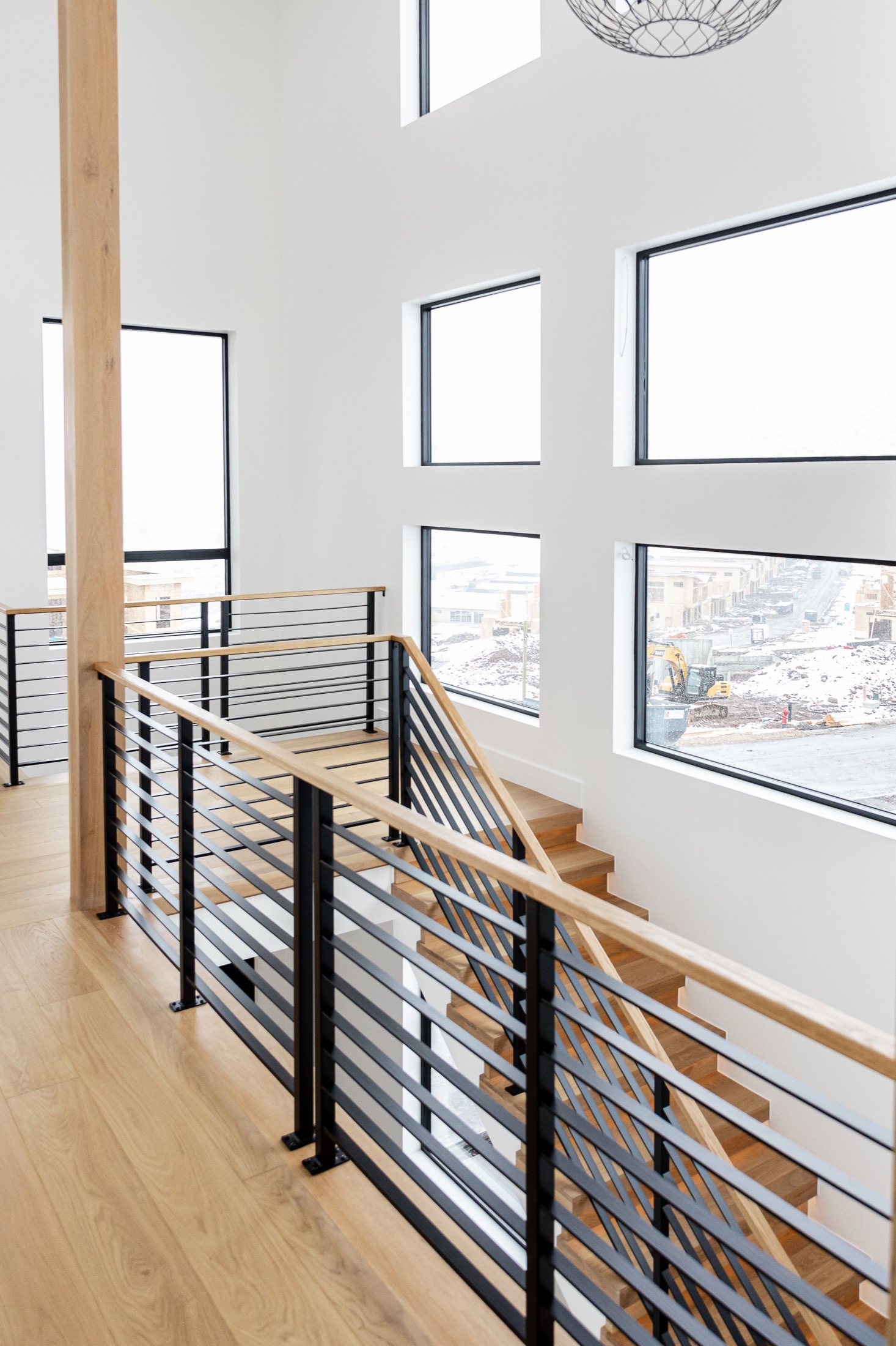 Benloch Ranch Lot 66 — staircase with black horizontal railings and wood treads