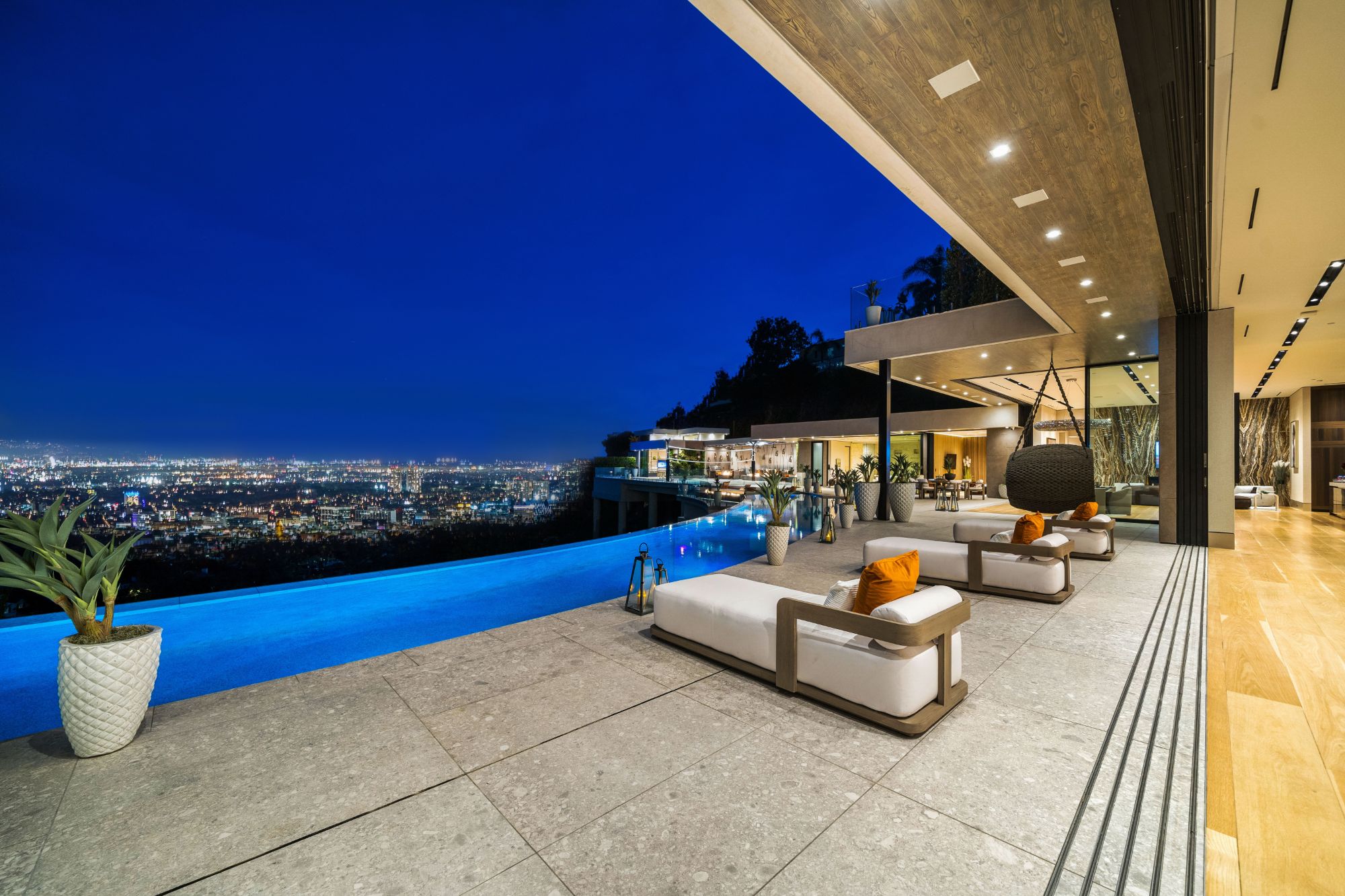 The Flicker Estate pool terrace at night over the city