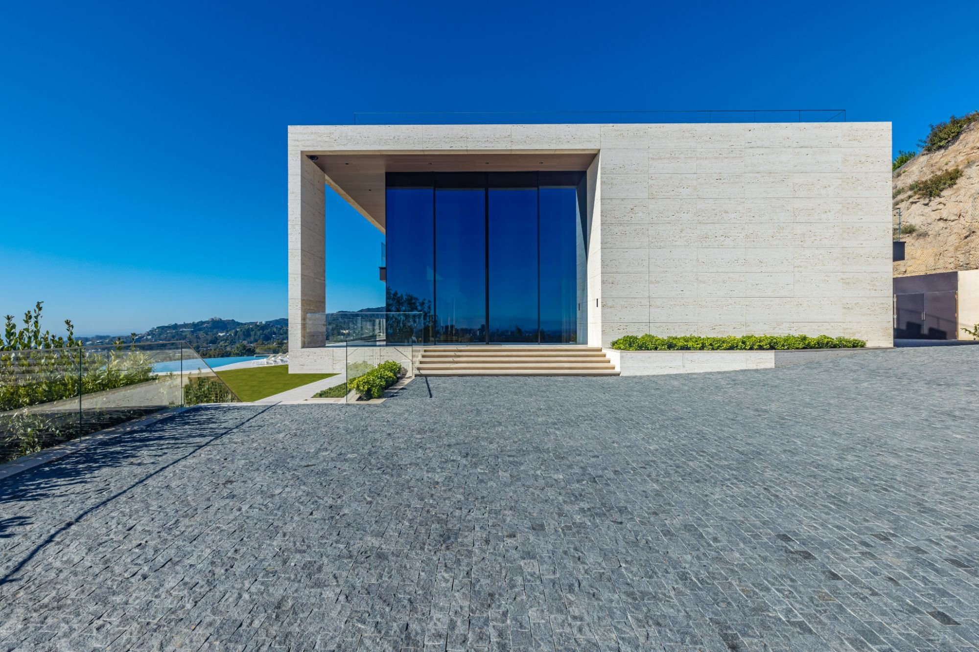 The Getty House — 684Firth Brentwood CA LA Exterior Entrance Travertine Stone Cobblestone Driveway Oversize Glass Doors  Modern 
