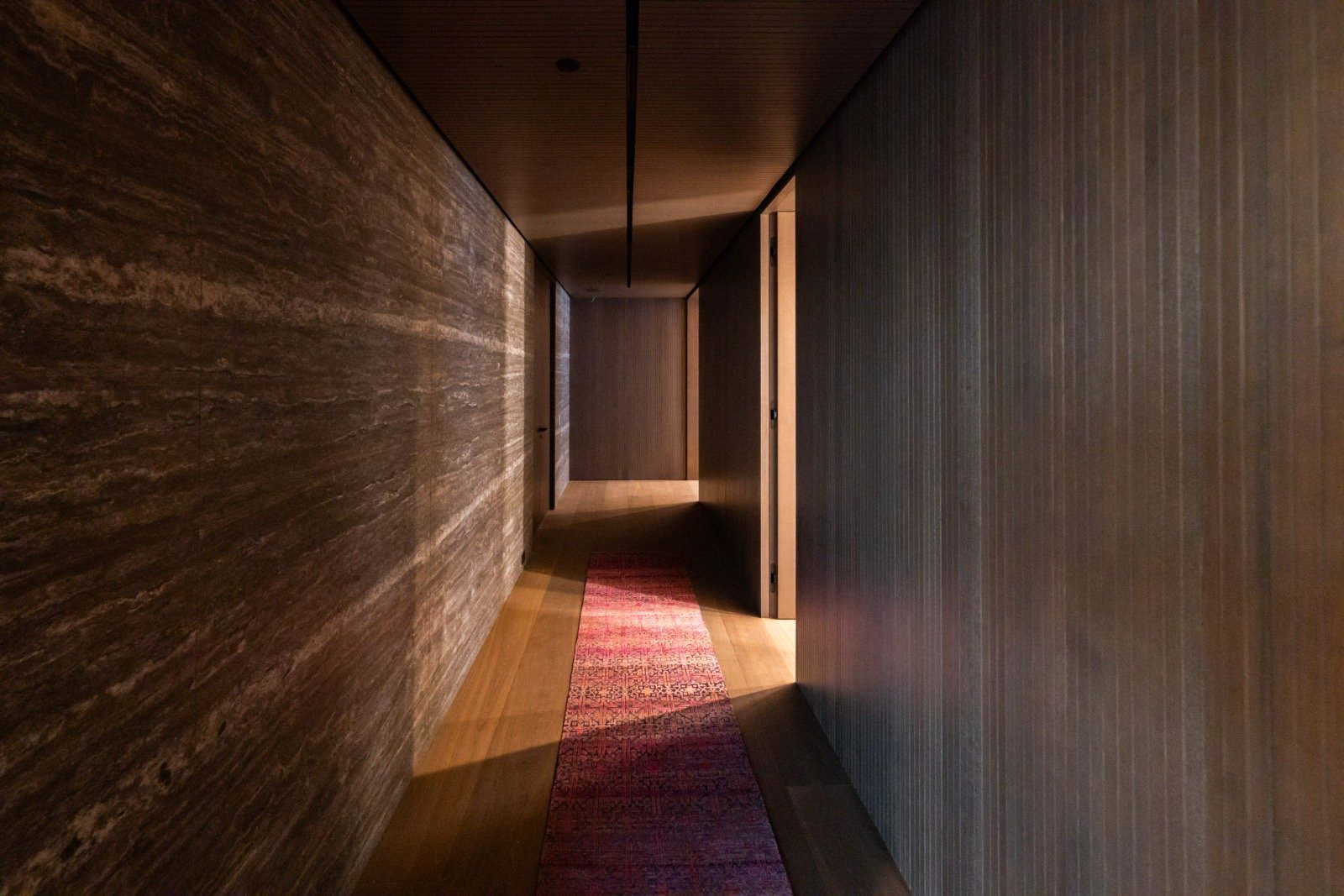 The Getty House — 684Firth Brentwood CA LA Interior Hallway Stone Accent Wall Wood Paneling Linear Lighting  Modern Home