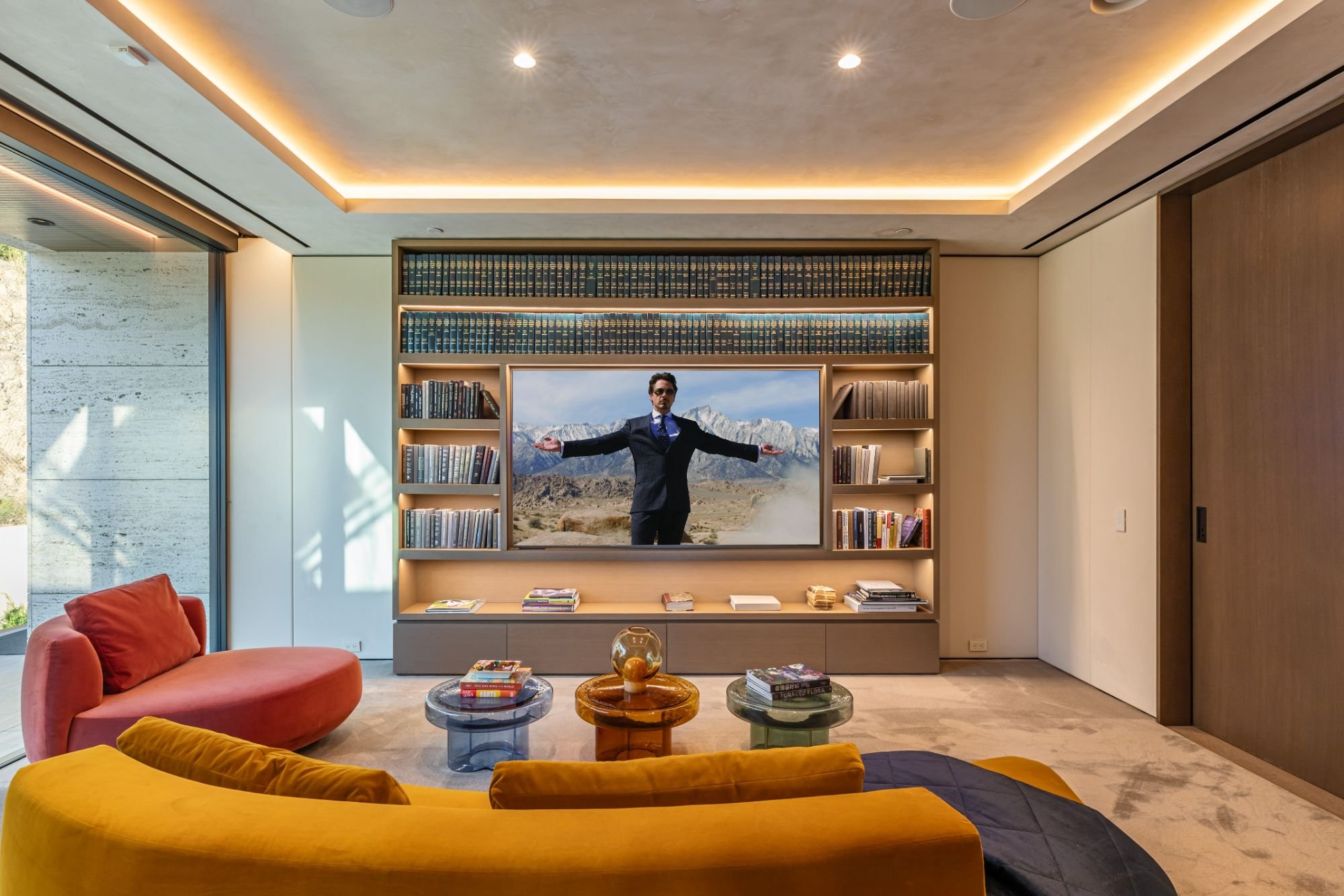 Getty House — media room with built-in shelving and curved sofa