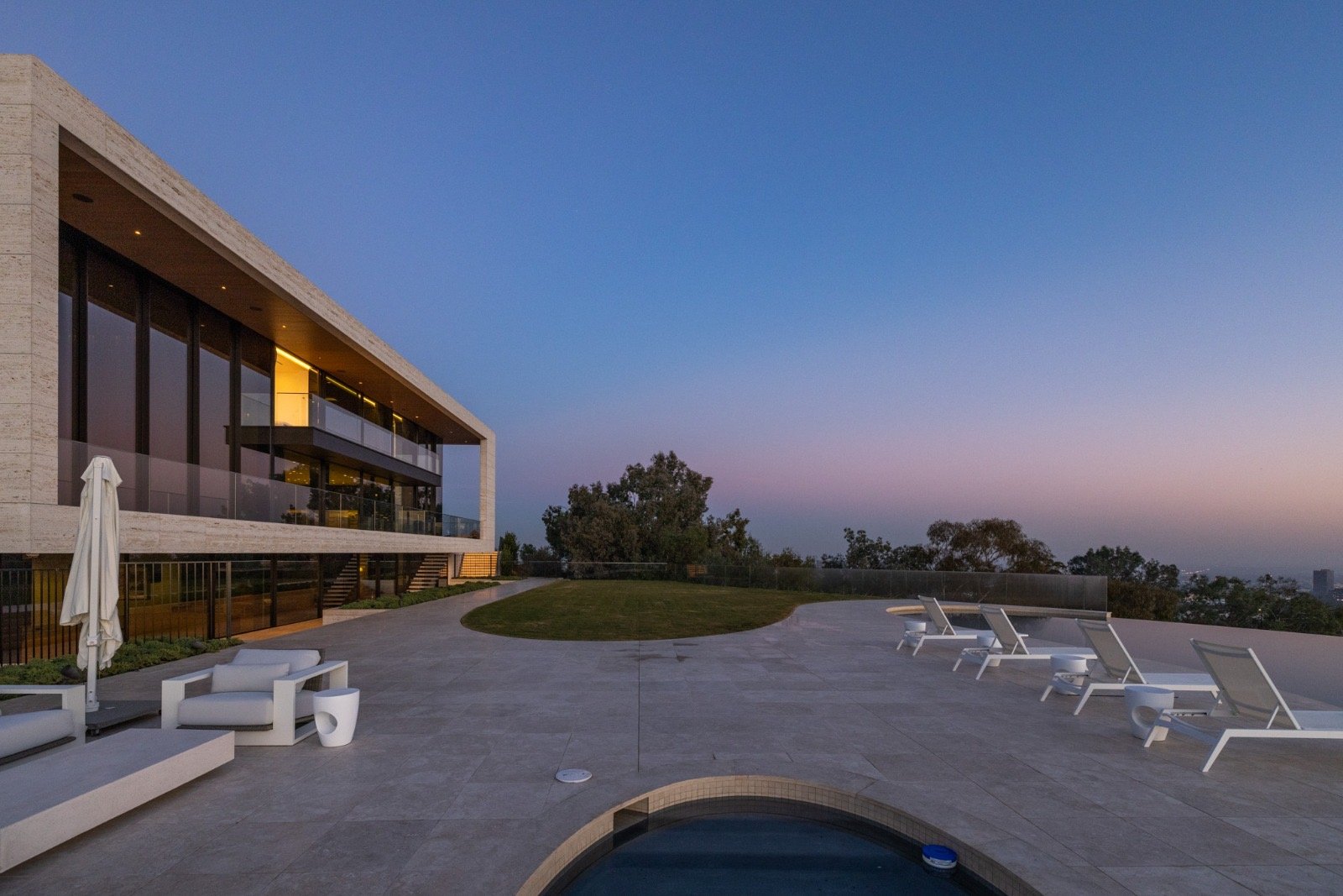 Getty House — travertine pool deck and terrace at sunset