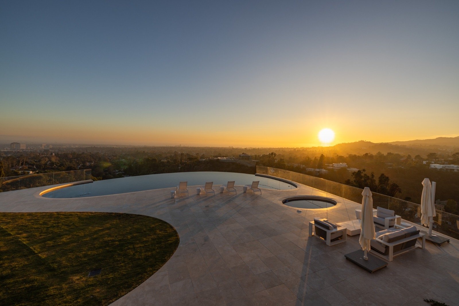 Getty House — pool terrace lounge with panoramic city view at sunset