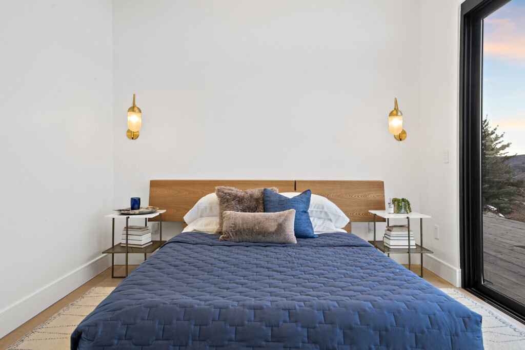 Icon Haus — bedroom detail with wood headboard and brass sconces