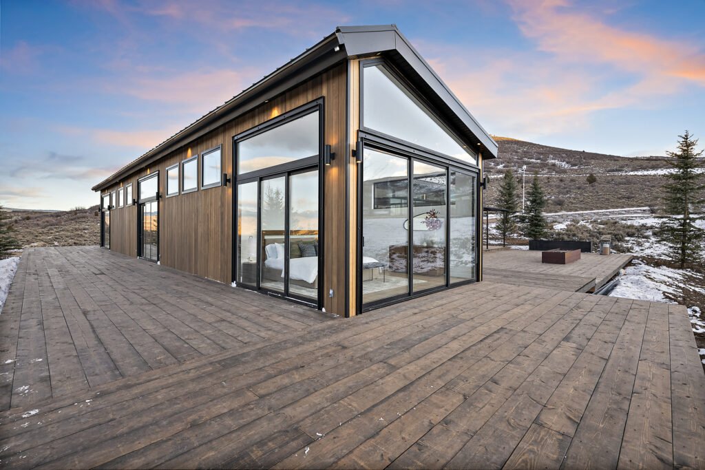Icon Haus — glass walls and deck glowing at sunset