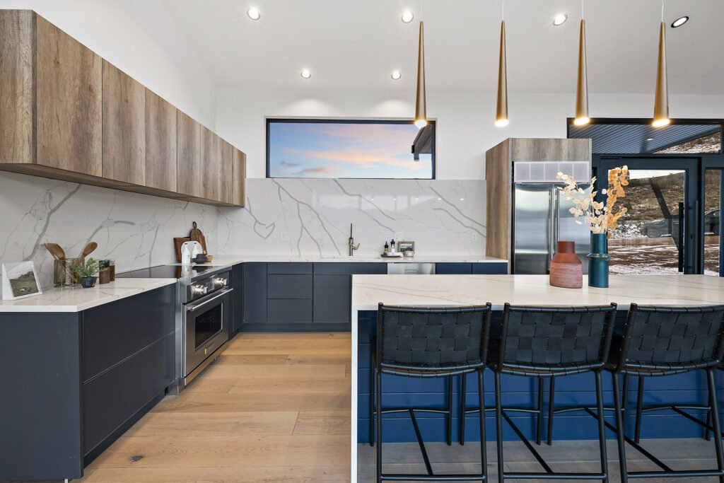 Icon Haus — kitchen detail: navy cabinetry, wood uppers, marble and quartz