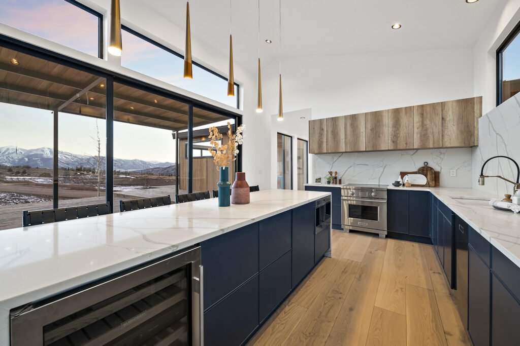 Icon Haus — navy island kitchen with wine fridge and mountain view