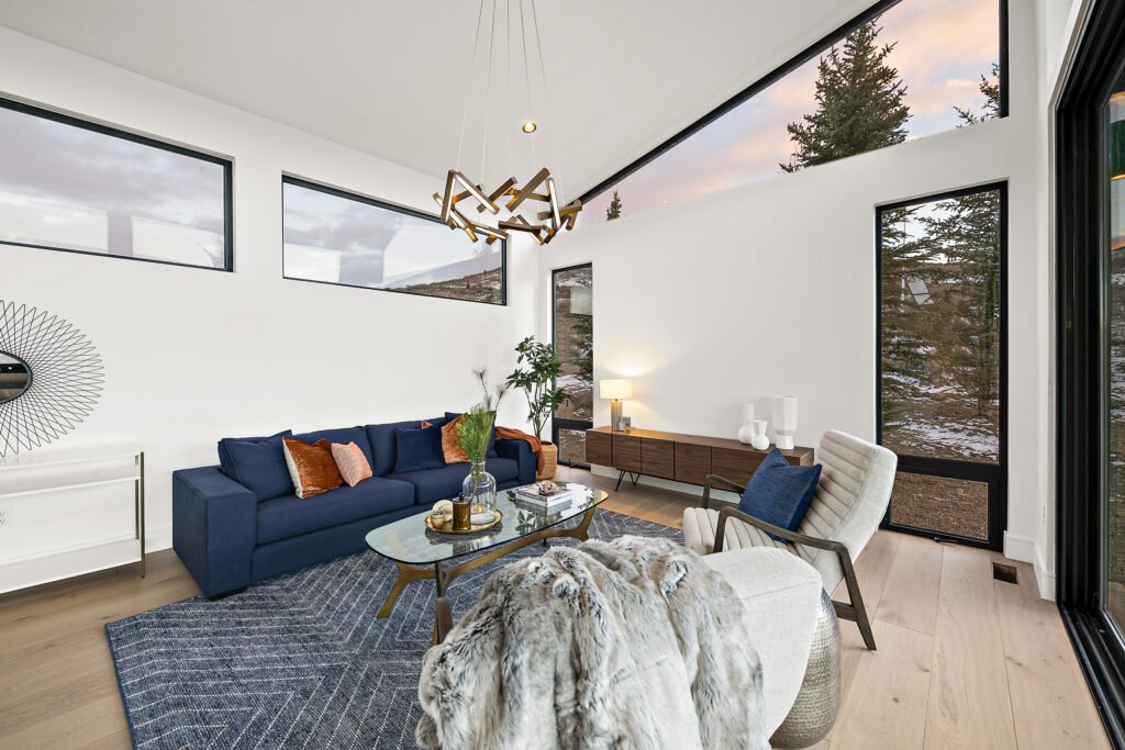 Icon Haus — living room vignette with navy sofa and wood credenza beneath sculptural lighting