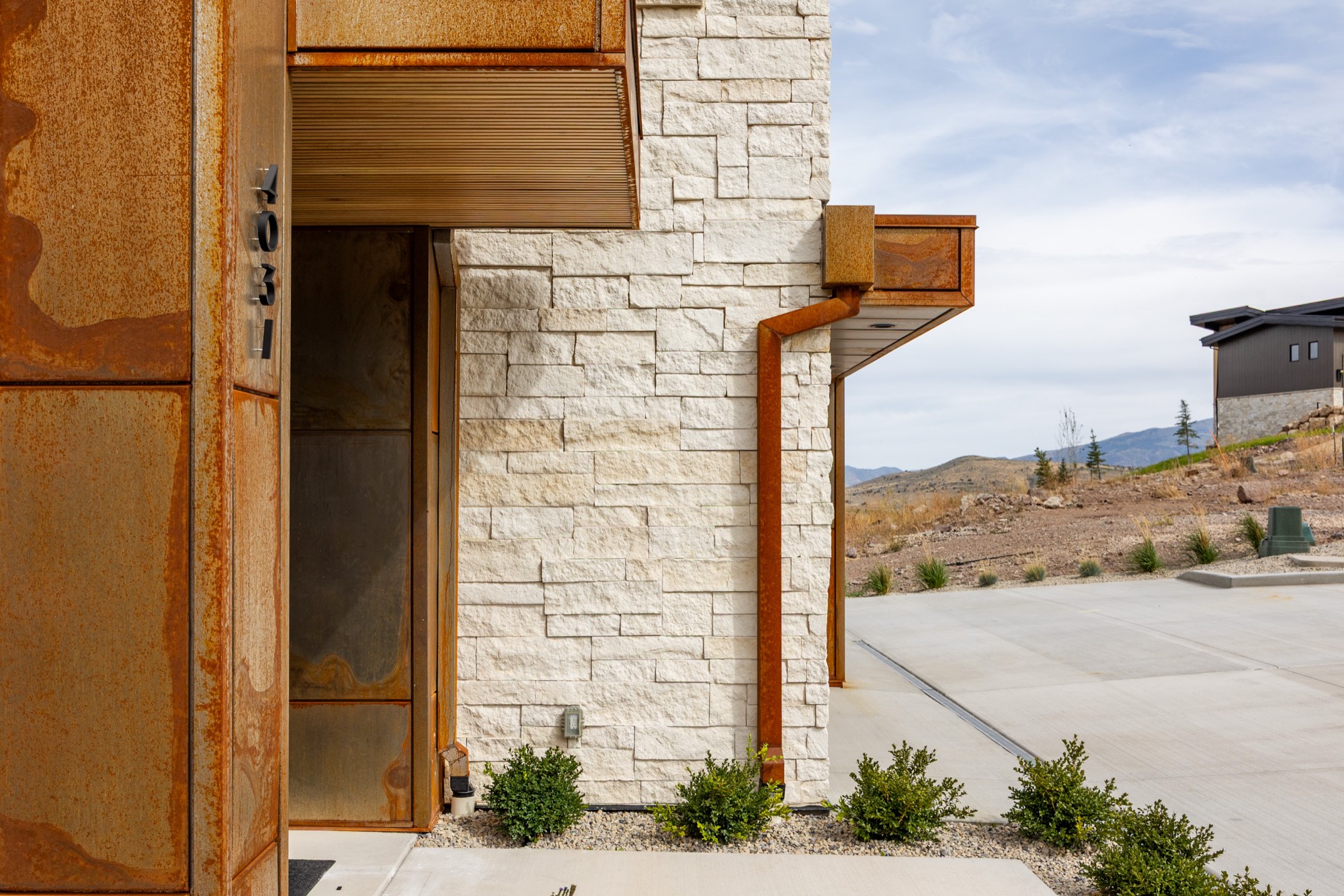 Islay Way — corten steel entry detail against white limestone