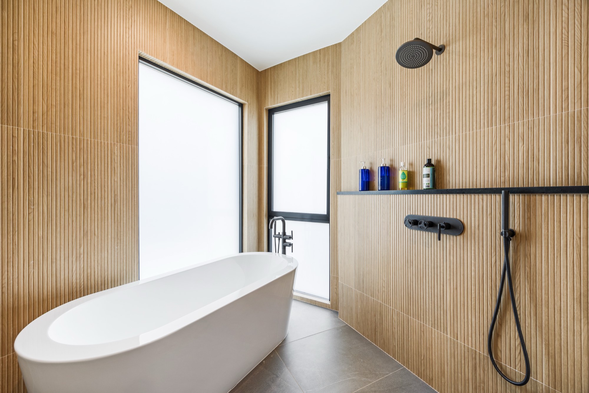 Islay Way — primary bath, freestanding tub wrapped in teak slat walls