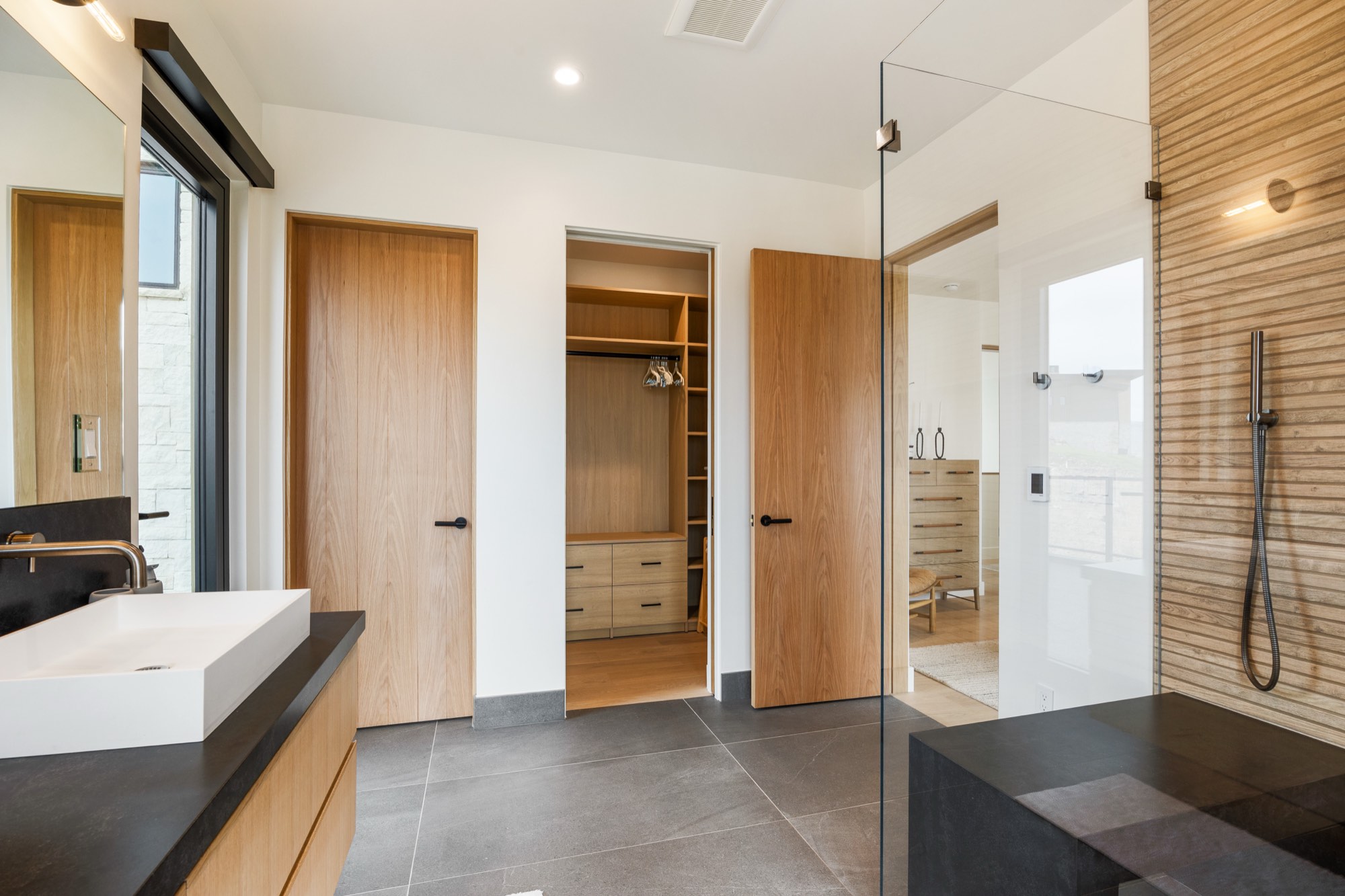 Islay Way — primary bedroom with linear fireplace and hillside view