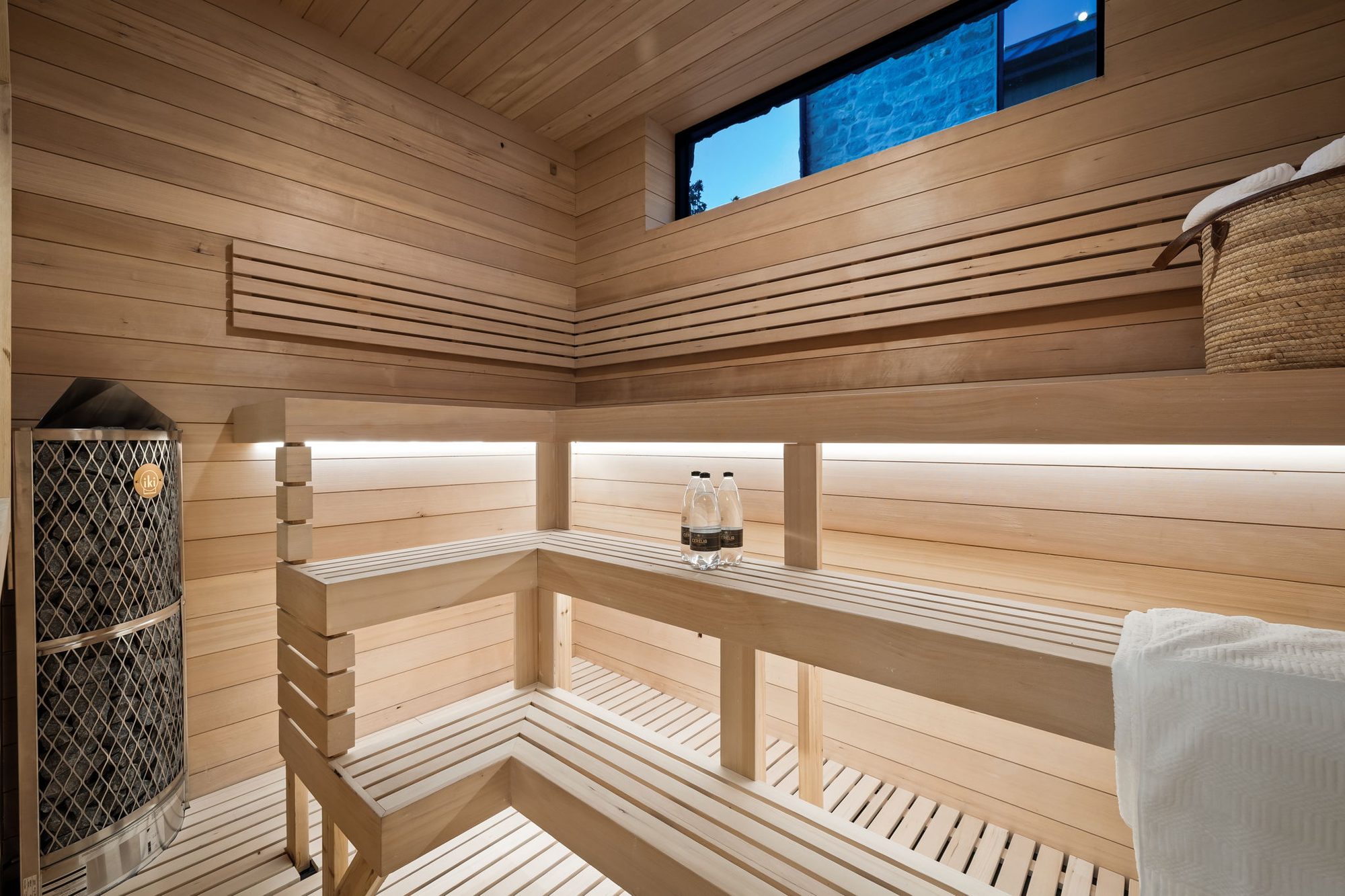 Lumen — cedar sauna with tiered benches and a window to the valley