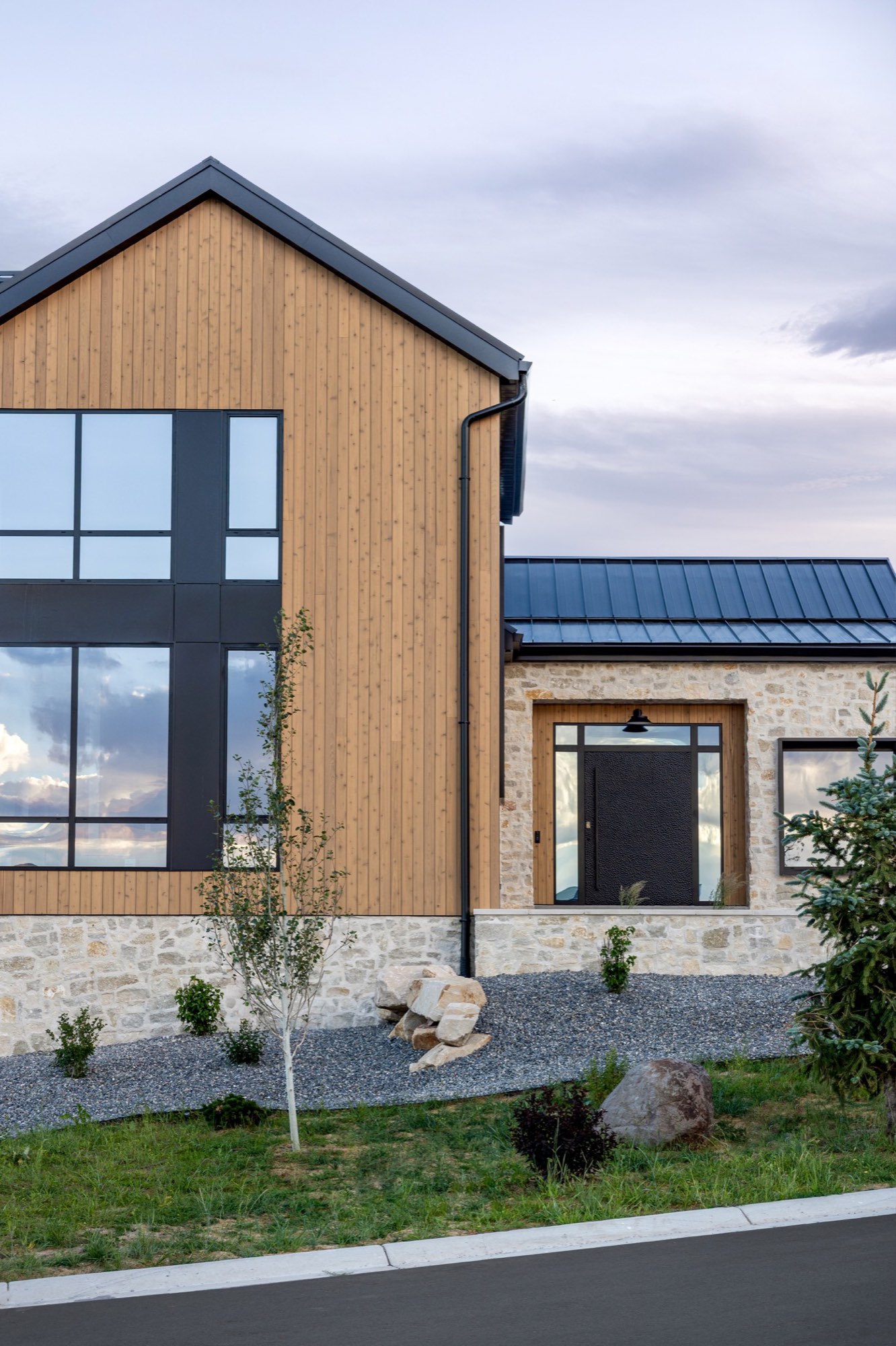 Lumen — glass gable and entry under an evening sky