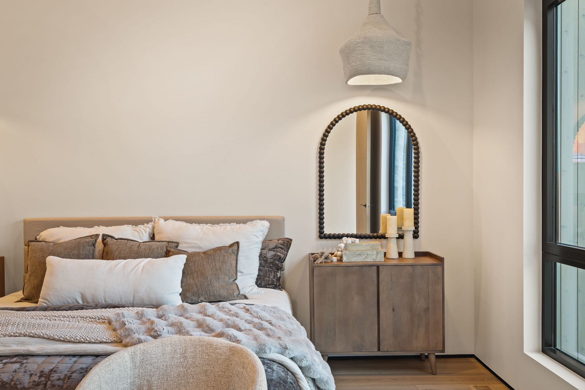Lumen — guest bedroom with an upholstered bed and arched mirror