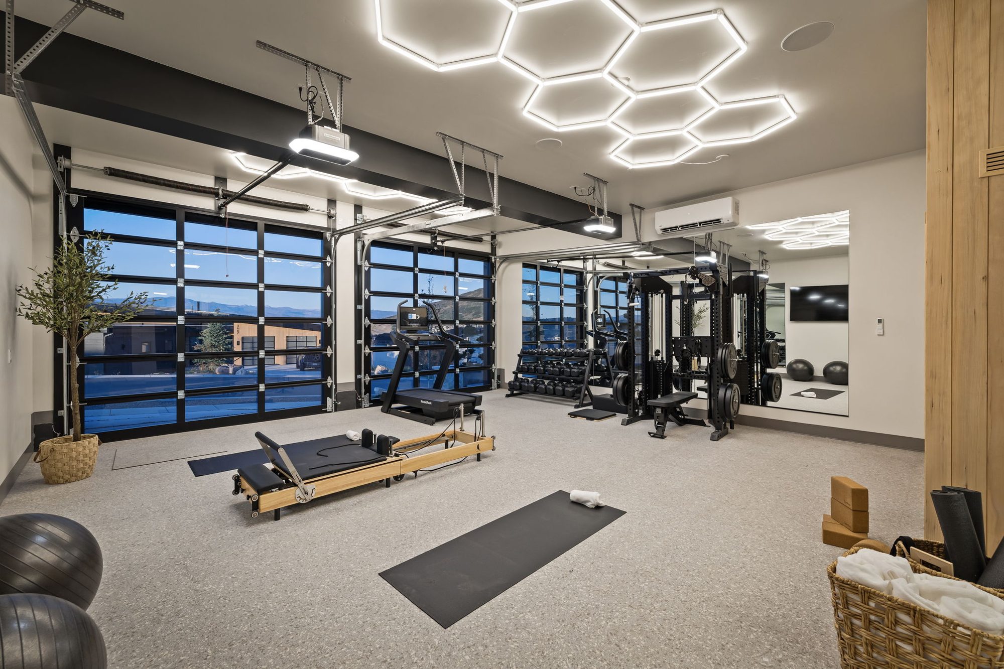 Lumen — home gym with glass garage doors open to the hillside