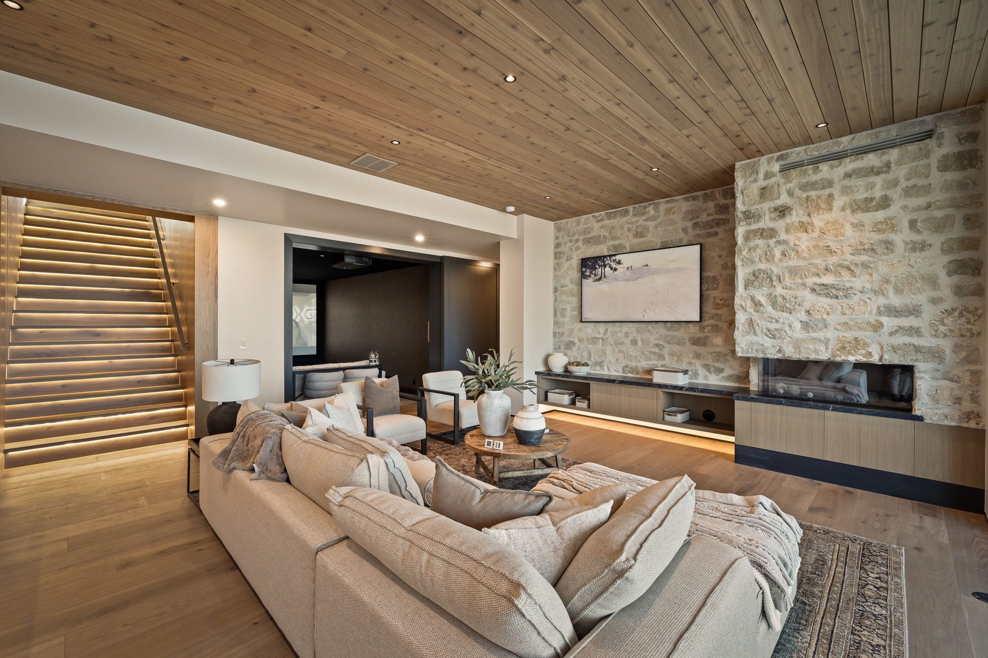 Lumen — linear fireplace set into the stone wall beside the floating stair