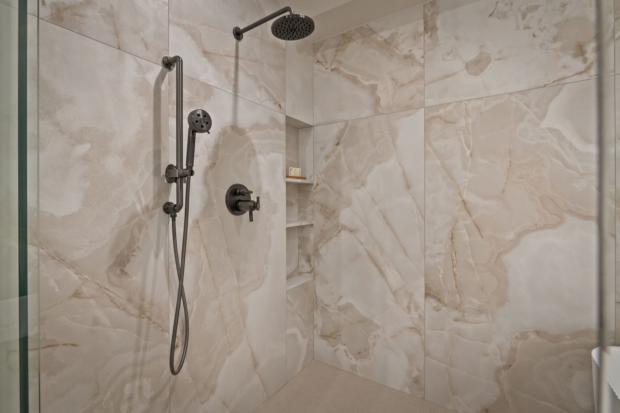 Lumen — walk-in shower clad in a book-matched stone slab