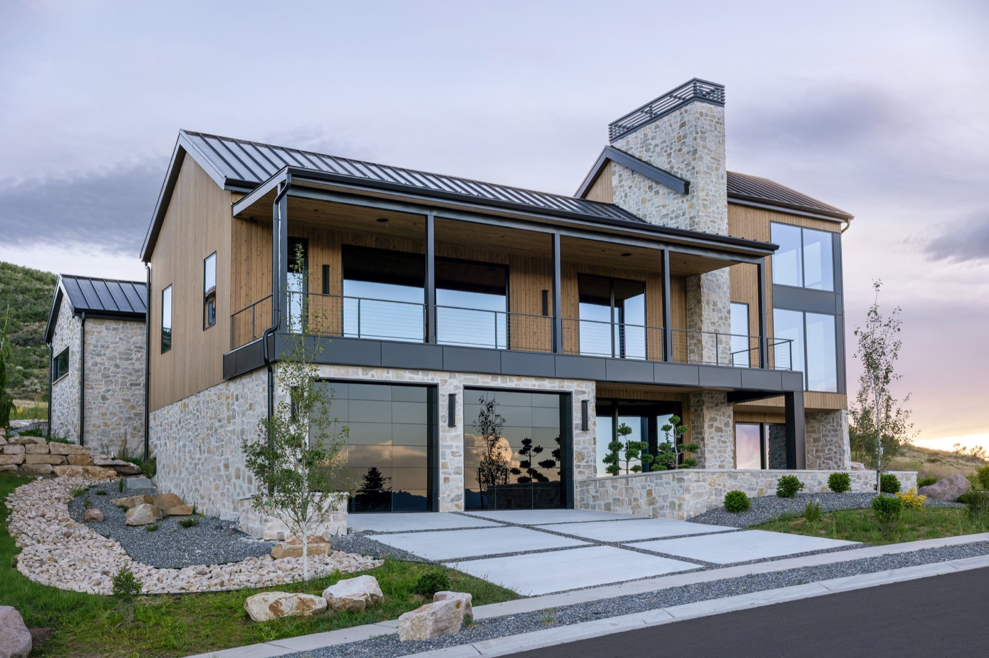 Lumen — mountain modern home at dusk, stone chimney and glass, Benloch Ranch, Heber City