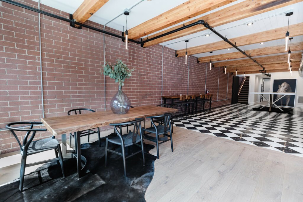 Main Street — dining space against the preserved brick wall under timber beams